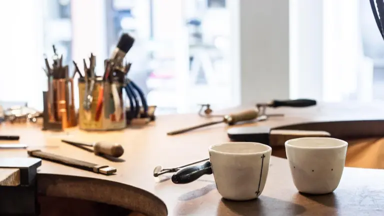 Atelier d’artiste avec outils de linogravure et tasses sur une table