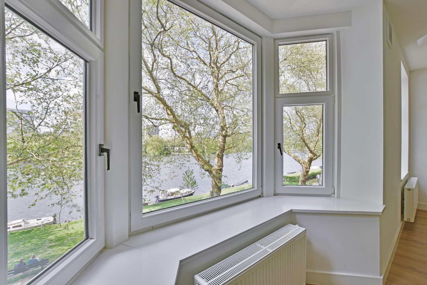 jolies fenetres en PVC donnant vue sur un lac avec un bateau